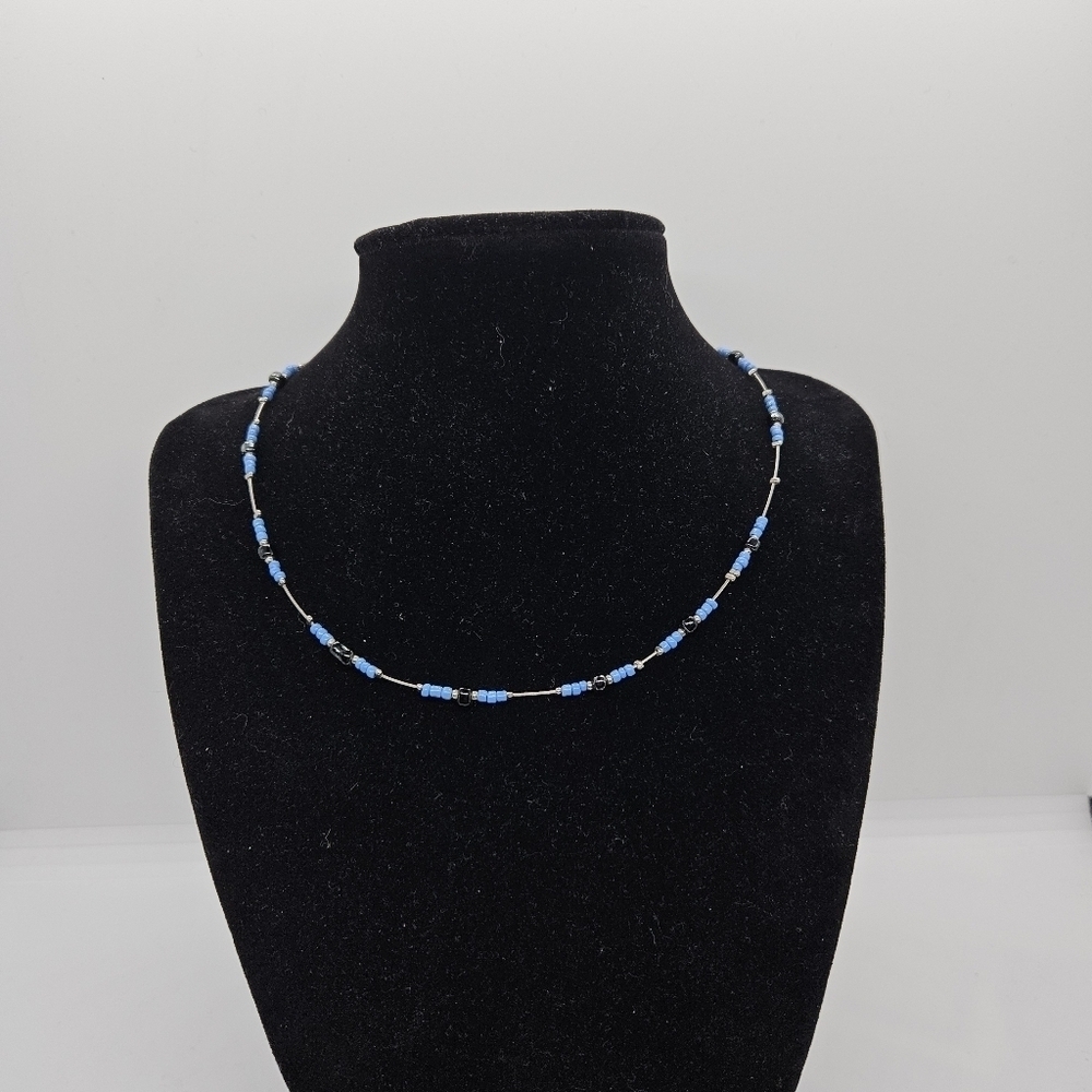 silver tone wire necklace with blue and black beads